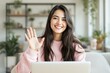 © Pixels Hunter - Young woman smiling and waving while working on a laptop in a bright room.