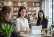 © ikbal - Two professional women discussing business strategies while working on a laptop in a bright and modern office space