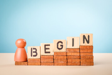 Wall Mural - the word begin spelled out with alphabet blocks on wooden steps arranged in ascending order