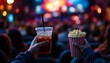 © AITOMF - POV of holding cinema popcorn in a bucket with a drink