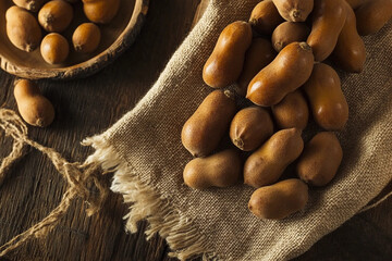 Collection of tamarinds arranged on a cloth spread on a rustic table showcasing natural texture and colors