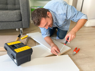 Wall Mural - Man assembling new furniture at home do-it-yourself concept