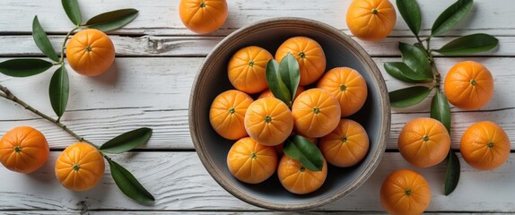 Canvas Print - Organic Mandarin Oranges in Bowl Surrounded by Fresh Green Leaves on Rustic White Wooden Surface With Space for Text or Branding