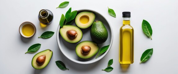 Wall Mural - Sliced Avocados With Olive Oil Bottles And Fresh Leaves On White Background Healthy Eating Concept With Space For Text Or Branding