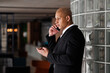 © Dmytro Hai - African american businessman talking on smartphone in hotel