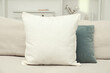 © New Africa - Blank soft pillow on cozy couch indoors