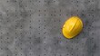 © Matcha_09 - Top view of a yellow hard hat sitting on a perforated steel sheet, industrial background.