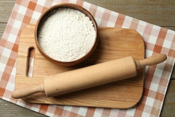 Wall Mural - Rolling pin, bowl of flour and board on wooden table, top view