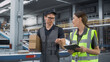 © Gorodenkoff - Caucasian Female Manager And Male Load Worker Walking In Warehouse With Automated Conveyor Belt, Using Tablet. Man And Woman Working With Orders Of Online Customers In Distribution Center.