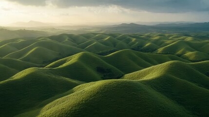 Wall Mural - Aerial view showcasing a lush green mountain range beneath a dramatic cloudy sky, highlighting nature's beauty and serene landscape.