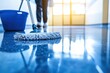 © nurman - Sparkling clean floor being mopped, close-up view of mop and bucket, blurred person in background, emphasizing cleanliness and hygiene.