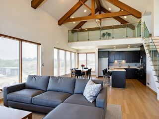 Bright Living Room Interior with Gray Sofa Wood Floors and High Ceiling