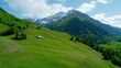 © A4719 - A picturesque valley with a small home, surrounded by lush greenery and snow capped mountains under a bright sunny sky
