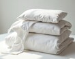 © Maryna - Freshly washed white cotton bed sheets neatly folded. Clean surface in room. Bedding set plain soft smooth comfortable luxury household decor fabric. Home interior linen duvet stack sleep rest