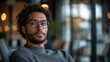 © Lisouski Uladzimir - Confident young man in glasses sitting in modern cafe with warm lighting