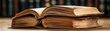 © Kakabe - A stack of aged, open books rests on a wooden table, showcasing their worn pages and rich texture, This image is ideal for educational materials, literary blogs, or vintage-themed projects,