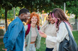 © Jose Calsina - Group of multiracial teenage students talking and laughing outdoors, enjoying friendship and bonding moments in a vibrant, youthful, and cheerful expressions at university campus. Friends having fun