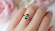 © Anna - Elegant emerald ring on female hand with soft pink manicure