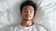 © Denisa - Young man lies on a white bed with closed eyes, enjoying a relaxing sleep in a sunlit room
