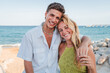 © Jose Calsina - Joyful Young Couple Embracing Each Other with Smiles Against the Ocean on a Beautiful Sunny Day, Two people enjoying their summer vacations on the beach. Portrait of friends at coastal sea shore