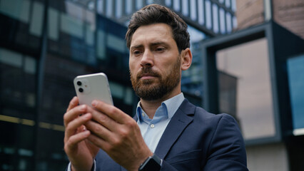 Caucasian male businessman guy business employer adult man smartphone user internet connection mobile phone gadget addicted outdoors browsing cellphone screen typing sms online app shopping in city