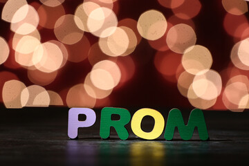 Wall Mural - Word PROM on dark table against blurred lights