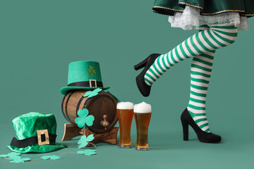 Wall Mural - Woman in waitress costume with glasses of beer, leprechaun's hats, barrel and clovers on green background. St. Patrick's Day celebration