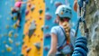© Prostock-studio - Children engage in climbing activities on a vibrant indoor wall, showcasing teamwork and focus as they practice their climbing technique with safety gear.