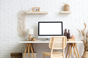 Wall Mural - Stylish workspace with modern computer and pampas grass near white brick wall