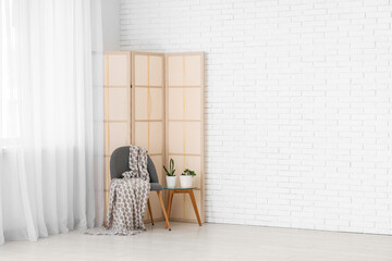 Wall Mural - Armchair with table and folding screen near light curtain in room