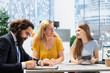 © DC Studio - Financial advisor signing documents in office after happy mother decides to invest in daughter education. Agent writing signature on paperwork, assisting woman with receiving student loan for her girl
