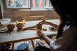 © DimaBerlin - Woman potter hands gently wet and align clay cup with sponge on workshop table, ensuring smooth surface. Pottery ceramic technique, handmade crockery, artisanal craft, small business, pottery school
