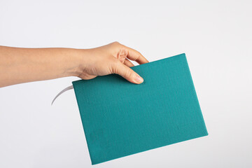 Wall Mural - Blank blue book cover in hand on white background.