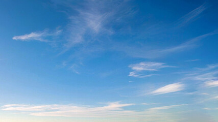 Wall Mural - blue sky with wispy clouds the image features a clear blue sky adorned with wispy, delicate clouds. 
