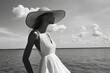 © Sean Hoong - A stylish woman standing at the shore, wearing a flowy dress and a sun hat, enjoying the summer breeze.