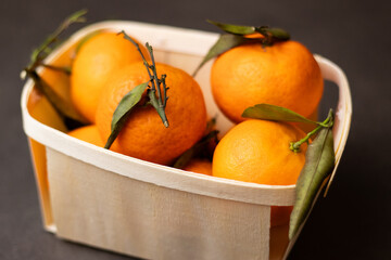 Wall Mural - Close up of mandarine fruits in a wooden box on grey table background