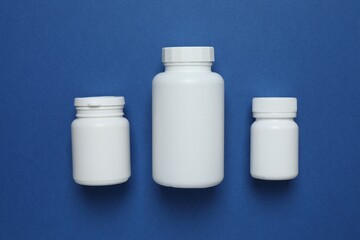 Wall Mural - White bottles on blue background, top view