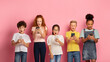 © Prostock-studio - Shocked schoolkids looking into their mobile phones over pink background