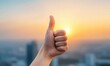 © Nuth - Thumb up gesture against a vibrant sunset background, signifying approval, positivity, and success in a cityscape setting.