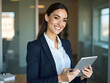 © Stock Image Paradise - Portrait of young Hispanic professional business woman standing in office. Happy female company executive, smiling businesswoman entrepreneur corporate leader manager looking at camera using tablet.