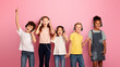© Prostock-studio - Multiethnic schoolchildren in headphones listening to music or audio books on pink background