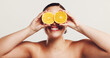 © KayExam/peopleimages.com - Happy woman, eyes or orange with citrus for vitamin C, detox or skincare nutrition on a white studio background. Female person, model or smile with natural organic fruit for health or anti aging skin