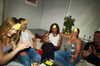 © Johnér - Group of cheerful friends playing guessing game at party