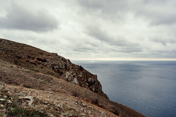 Wall Mural - coastal cliffs overlooking an expansive ocean on a cloudy day near a rocky shoreline