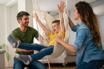 Wall Mural - Family from three people cheerfully spends fun time at home together. Parents, kid happiness concept