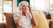 © peopleimages.com - Headache, massage and stress with senior woman on sofa in living room of apartment for pain relief. Burnout, migraine and temple with old person in retirement home for health, rest or wellness