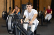 © JackF - Guy exercises on a rowing machine in the gym. European man is preparing for the rowing competition. Fitness club client at a group cardio workout