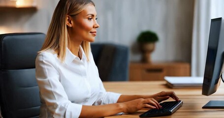 Poster - Woman Wearing White Shirt Working at Desk Using a Computer in Business Setting