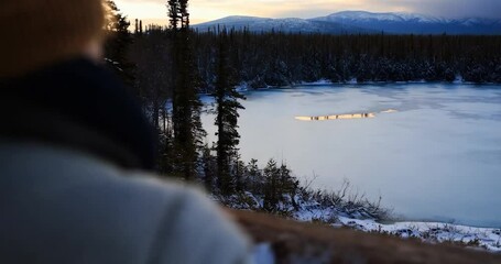 Poster - Frozen Lake with Mountain Background under a Sunset Sky in a Winter Landscape with Golden Light