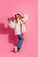 Wall Mural - Stylish young woman posing with disco ball against pink vertical background, celebrating glamour and fun